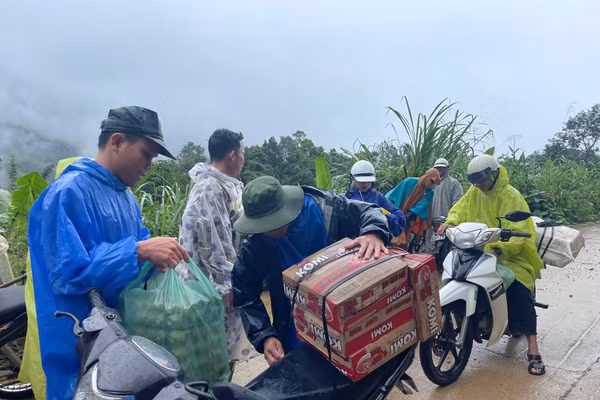 Lực lượng tình nguyện vận chuyển nhu yếu phẩm tiếp tế cho người dân đang tránh trú tại điểm trường Lăng Lương. Ảnh: Trà Thu. 