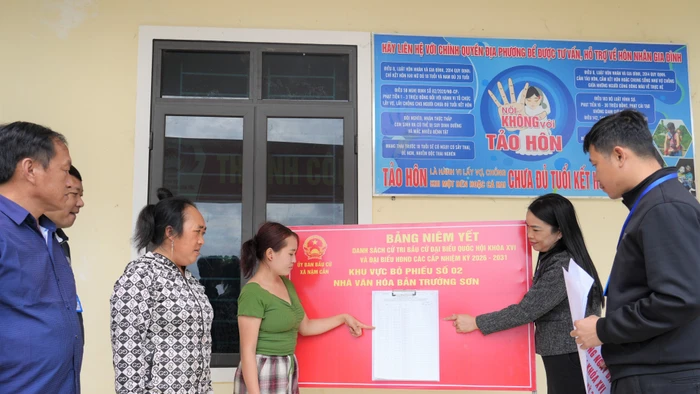 Cán bộ xã Nậm Cắn (Nghệ An) hướng dẫn người dân bản Trường Sơn đọc thông tin danh sách cử tri ở điểm bầu cử. Ảnh: Hồ Lài