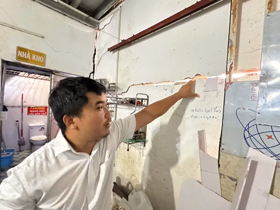 Ông Nguyễn Anh Sơn chỉ tay vào những vết nứt tường do công trình xây dựng kế bên gây ra. (Ảnh: Hà An)