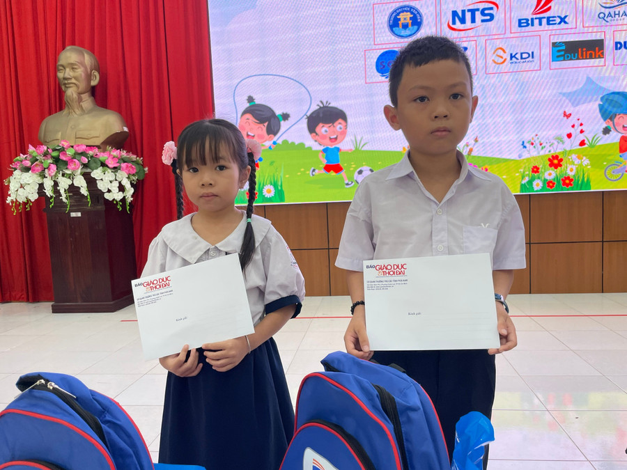 Trương Gia Bảo (phải) nhận học bổng và phần quà của Chương trình "Tiếp sức đến trường năm học 2025 - 2026" do Báo Giáo dục và Thời đại tổ chức, sáng 17/8. Ảnh: Hà An. 7231f43b13fb9ba5c2ea.jpg