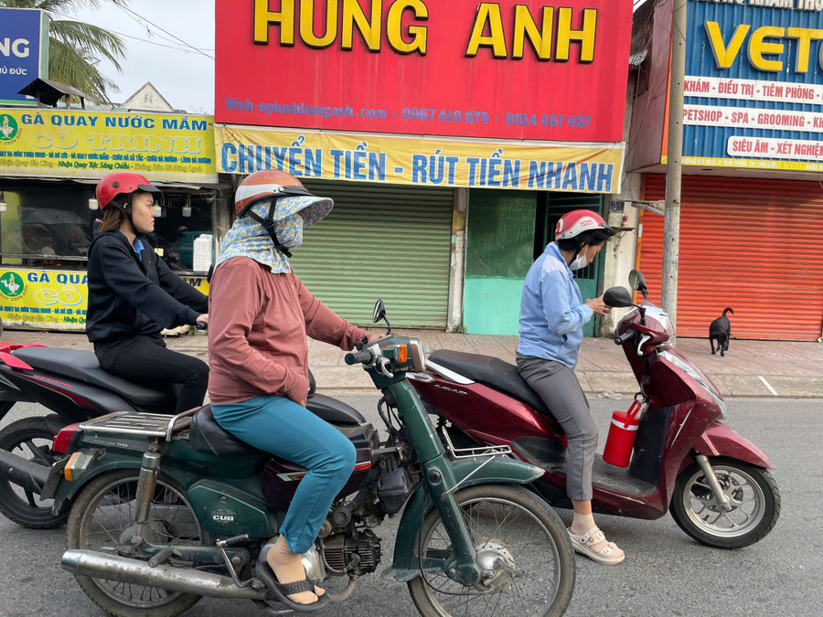 Người dân TPHCM mặc áo ấm ra đường sáng nay. Ảnh: Phúc Uyên