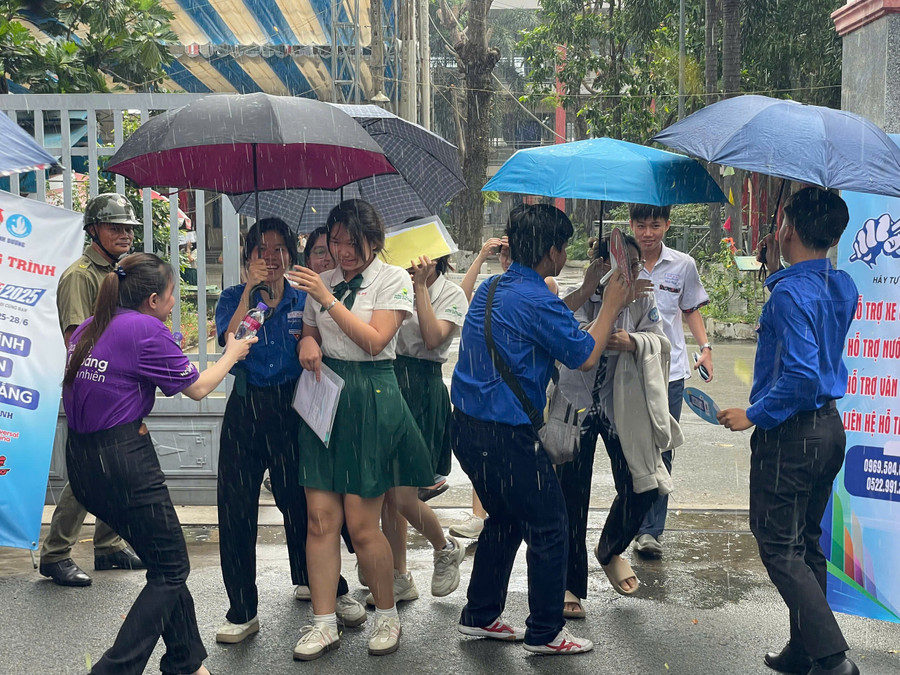 Sáng 26/6, tại điểm thi Kỳ thi tốt nghiệp THPT năm 2025 ở trường THPT Dĩ An, sau khi thi xong môn Ngữ văn trời bắt đầu xuất hiện mưa nặng hạt. Ngay lập tức các tình nguyện viên đến cổng trường che ô cho thí sinh.