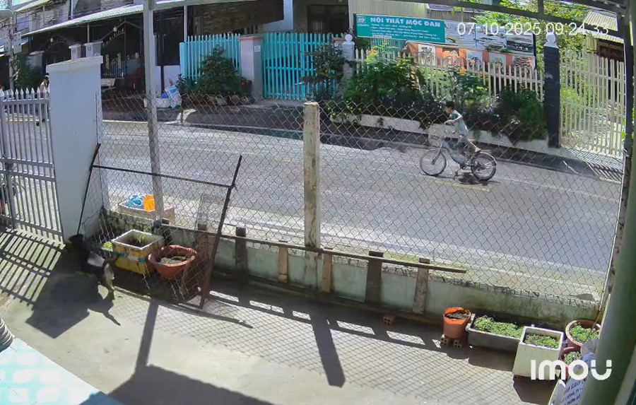 Bé trai đạp xe đuổi theo người giật vé số trong bất lực. (Ảnh cắt từ clip).