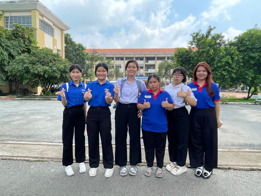 Thí sinh chụp hình cùng tình nguyện viên tại điểm thi Trường THPT Bến Cát sau khi hoàn thành kỳ thi. thi-ben-cat-1.jpg