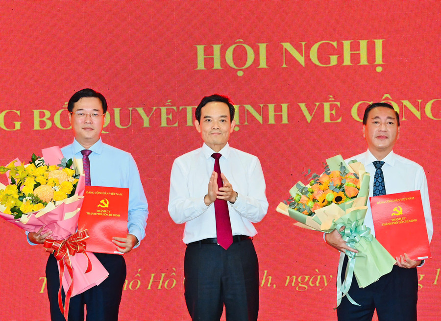 Ông Phạm Thành Kiên (phải) và ông Lê Quốc Phong nhận quyết định từ Bí thư Thành ủy TPHCM Trần Lưu Quang. Ảnh: SGGP