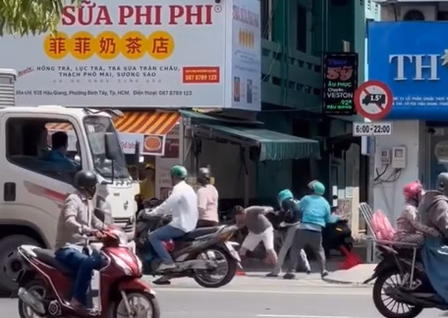 Nhóm người đánh nhau loạn xạ trên đường Hậu Giang, trong đó có một số người mặc áo xe ôm công nghệ. (Ảnh cắt từ clip)