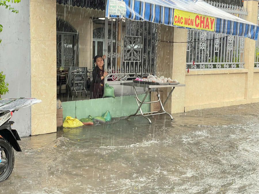 Để tránh nước tràn, một chủ nhà dùng bao cát, tấm sắt chắn trước cửa ra vào. ngap-thu-duc-9.jpg
