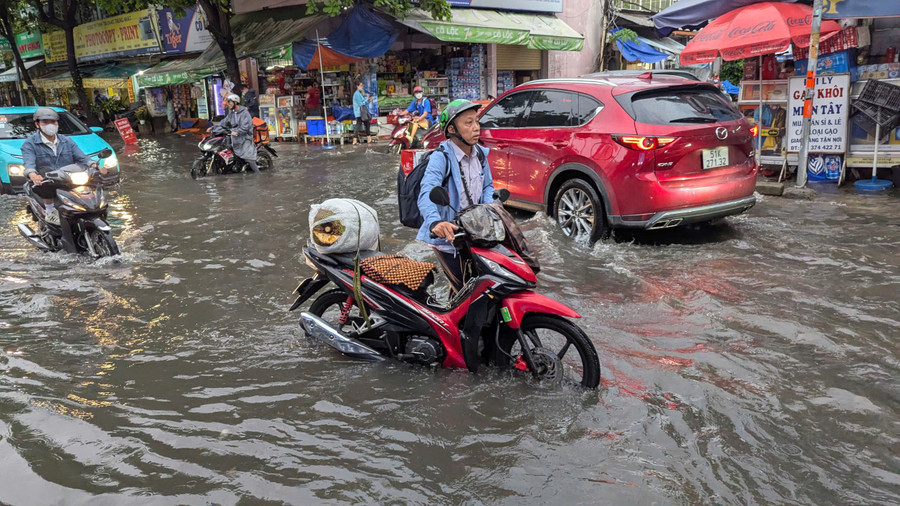Người đàn ông dắt bộ xe chết máy khi cố gắng chạy qua chỗ ngập trên đường Quốc Hương. ngap-46-1.jpg