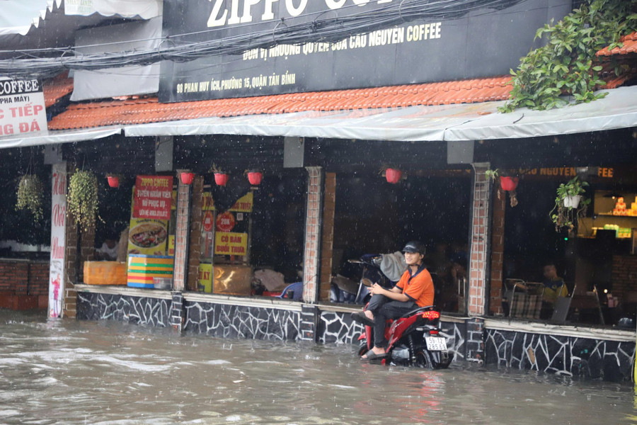 Đến 7h, nhiều tuyến đường ở TPHCM vẫn còn ngập, khiến việc đi lại, buôn bán của người dân gặp khó khăn. b1d6babae04a6814315b.jpg