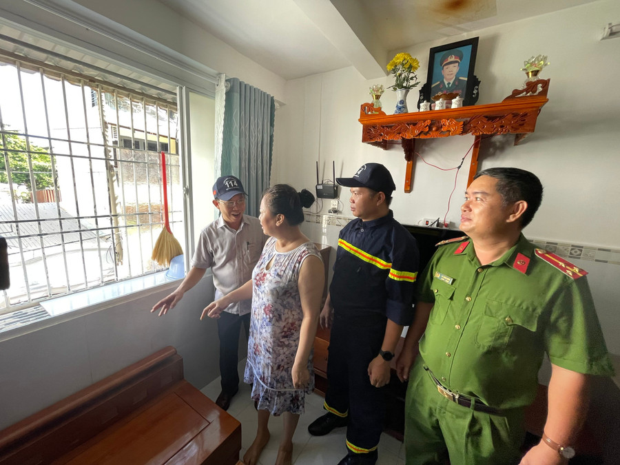 Ông Mai Quang, Phó Chủ tịch UBND phường Bình Quới (trái) cùng lực lượng chức năng vận động người dân Chung cư Thanh Đa tháo dỡ "chuồng cọp". Ảnh: Hà An.