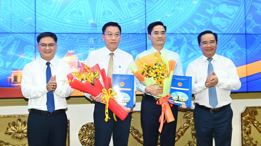 Ông Trần Quang Lâm, Giám đốc Sở Xây dựng TPHCM (thứ 2 từ phải sang) và ông Nguyễn Anh Minh, Giám đốc đốc Ban Quản lý dự án đầu tư xây dựng các công trình giao thông TPHCM nhận quyết định bổ nhiệm từ lãnh đạo UBND TPHCM. (Ảnh: SGGP)