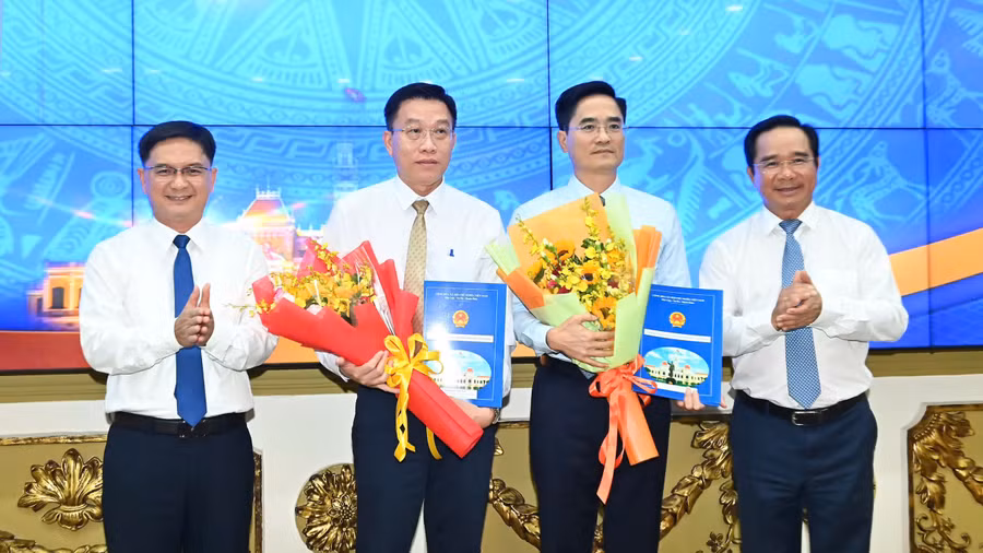 Ông Trần Quang Lâm, Giám đốc Sở Xây dựng TPHCM (thứ 2 từ phải sang) và ông Nguyễn Anh Minh, Giám đốc đốc Ban Quản lý dự án đầu tư xây dựng các công trình giao thông TPHCM nhận quyết định bổ nhiệm từ lãnh đạo UBND TPHCM. (Ảnh: SGGP)