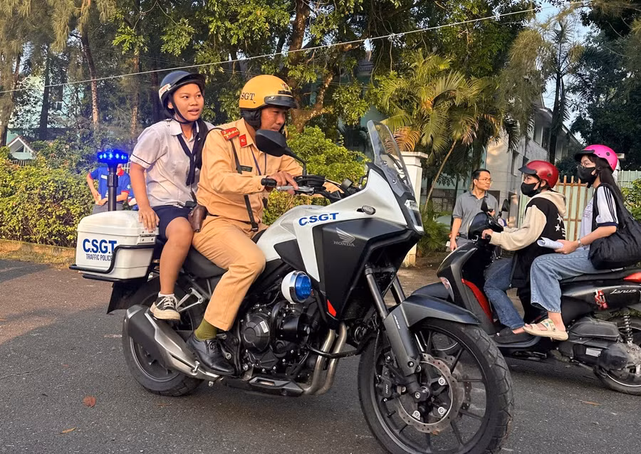 Đại úy Tạ Minh Thắng chở nữ sinh để quên giấy tờ tại điểm thi ở Hóc Môn, TPHCM. Ảnh: Phúc Uyên.