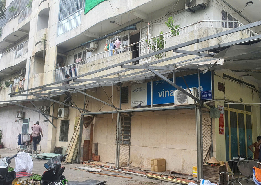 Người dân ở chung cư Độc Lập tự tháo dỡ phần mái che cơi nới sau vụ cháy khiến 8 người chết xảy ra hôm 6/7. (Ảnh: Phúc Uyên)
