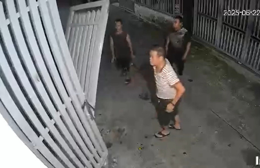 Bùi Hữu Khánh (áo sọc trắng) kéo sập cửa nhà hàng xóm vì bị phản ánh hát karaoke. (Ảnh cắt từ clip)