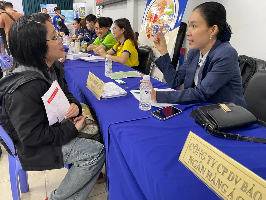 Đại diện doanh nghiệp tư vấn việc làm cho người lao động tại ngày hội. Ảnh: Hà An.