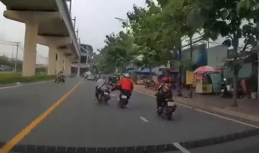 Nam thanh niên mặc áo cam đạp ngã người đi xe máy cùng chiều. (Ảnh cắt từ clip)