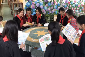 Học sinh đọc sách tại khuôn viên thư viện ngoài trời. Ảnh NT.