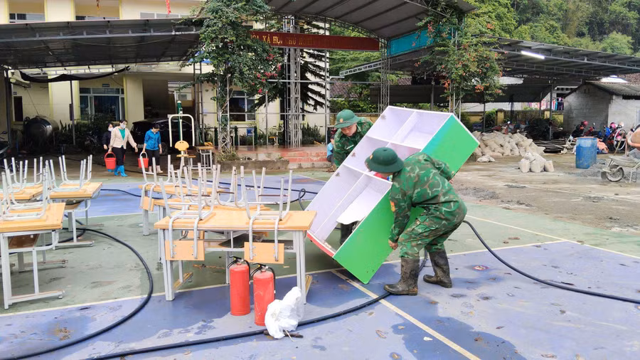 Lực lượng chức năng hỗ trợ khắc phục hậu quả thiên tai tại Trường Mầm non và Trường Tiểu học Minh Long.