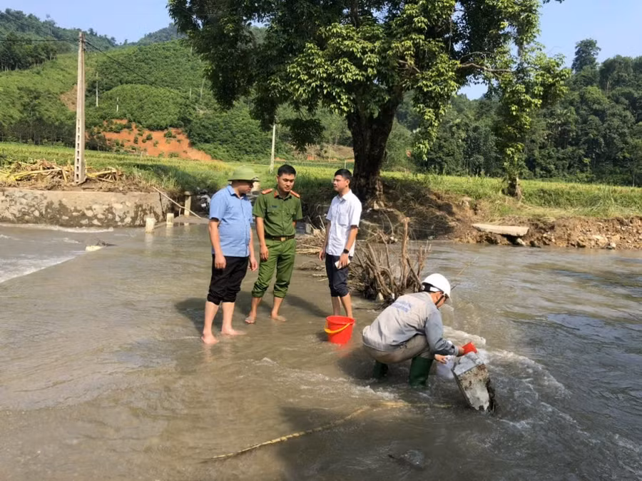 Cơ quan chức năng lấy mẫu xét nghiệm nước tại khu vực ảnh hưởng bởi sự cố. 