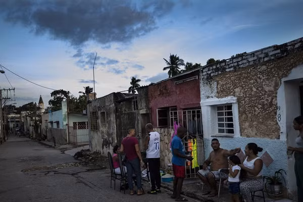 Người dân trò chuyện bên ngoài nhà trong thời gian mất điện nhiều ngày ở Havana, Cuba.
