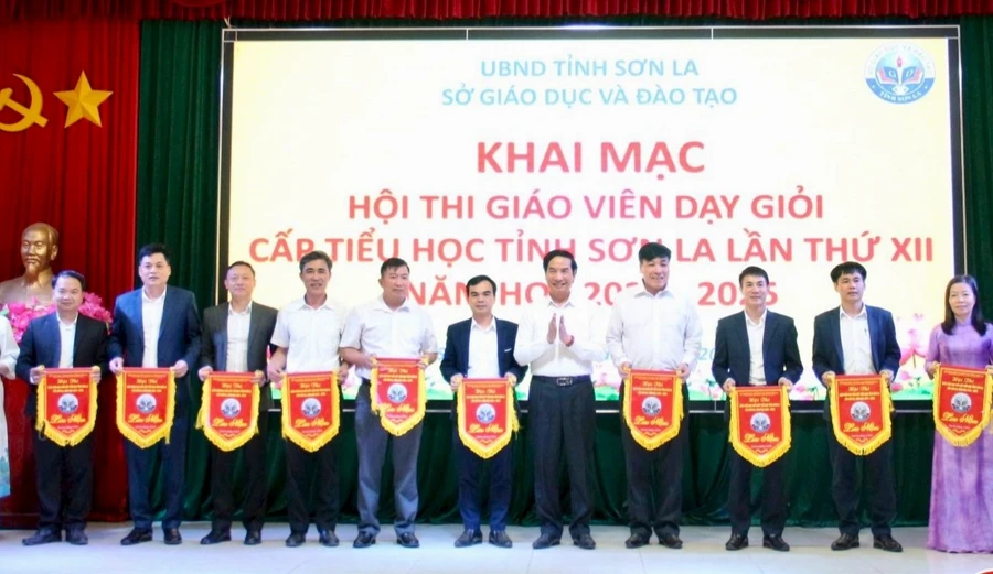 PGS.TS Nguyễn Huy Hoàng, Giám đốc Sở GD&ĐT tỉnh Sơn La trao cờ lưu niệm cho các đơn vị tham gia hội thi.