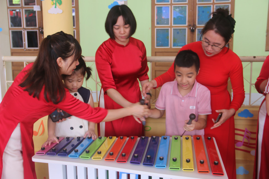 Các em học sinh khuyết tật được giáo viên dạy chơi nhạc cụ. img-8489.jpg