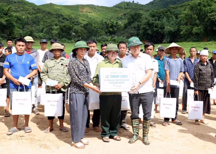 Phó Thủ tướng Lê Thành Long (người đầu tiên từ phải sang, hàng thứ nhất) tặng quà hỗ trợ người dân bị thiệt hại.