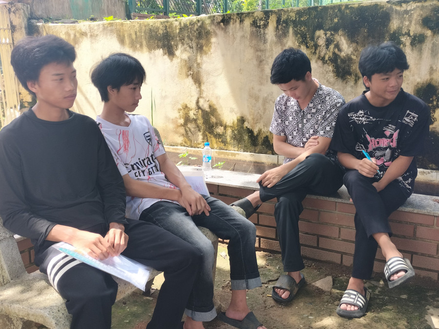 Các thí sinh tránh nắng giữa gốc cây xanh ở khuôn viên trường học. img20250625134441.jpg