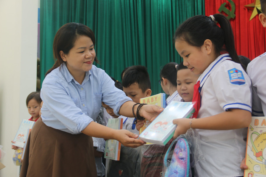 Đại diện Công ty cổ phần dịch vụ và thương mại sách và thiết bị Tây Bắc tặng vở cho học sinh. img-8621.jpg