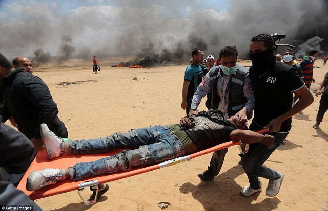 Một nhân viên y tế hỗ trợ đưa người bị thương đi cấp cứu