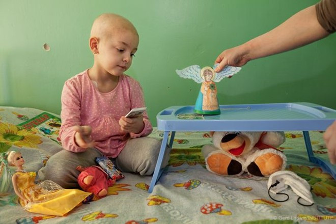 Veronika, 5 tuổi, mắc bệnh máu trắng và phải điều trị tại một bệnh viện ở Kiev. Khi thảm họa Chernobyl xảy ra vào năm 1986, cô Yelena, mẹ của em, mới 4 tuổi và sống gần nhà máy. Theo các bác sĩ, nhiều phụ huynh là nạn nhân trực tiếp của vụ nổ. Do nhiễm phóng xạ nên họ sinh ra những đứa con mắc bệnh hoặc phát triển không bình thường. Ảnh: Long Shadow Of Chernobyl 1
