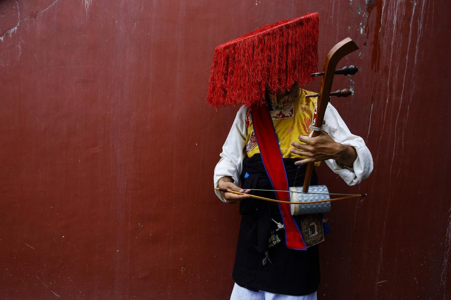 Một nghệ sĩ Tây Tạng chơi nhạc cụ trước lễ kỷ niệm sinh nhật lần thứ 82 của Dalai Lama ở Kathmandu, Nepal