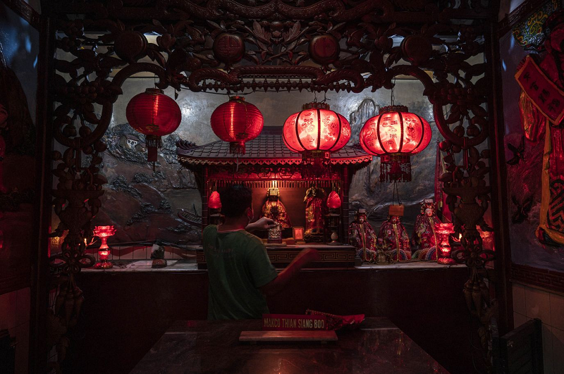 Một người đàn ông lau bức tượng tại một ngôi chùa ở Surabaya, Indonesia. (Ảnh: Juni Kriswanto/AFP/Getty Image).