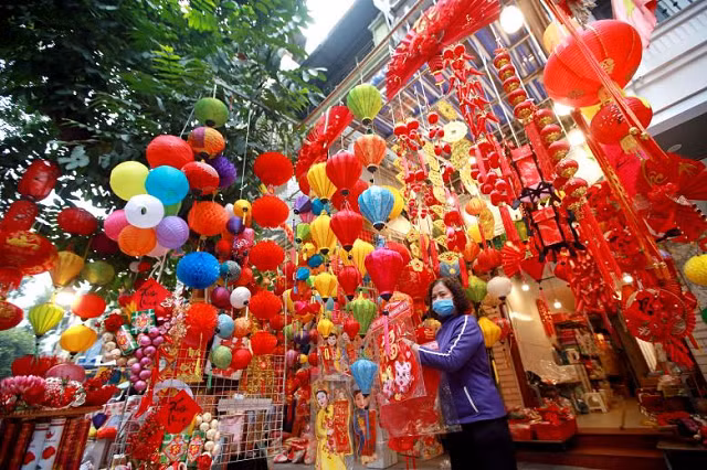 Một phụ nữ bán đồ trang trí trước Tết Nguyên đán trên một con phố ở Hà Nội, Việt Nam.