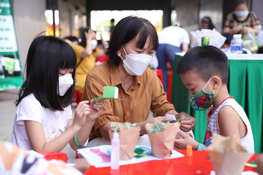 Các em nhỏ chăm chú cắt ráp anh hùng rùa xanh bằng giấy Các em nhỏ chăm chú cắt ráp anh hùng rùa xanh bằng giấy