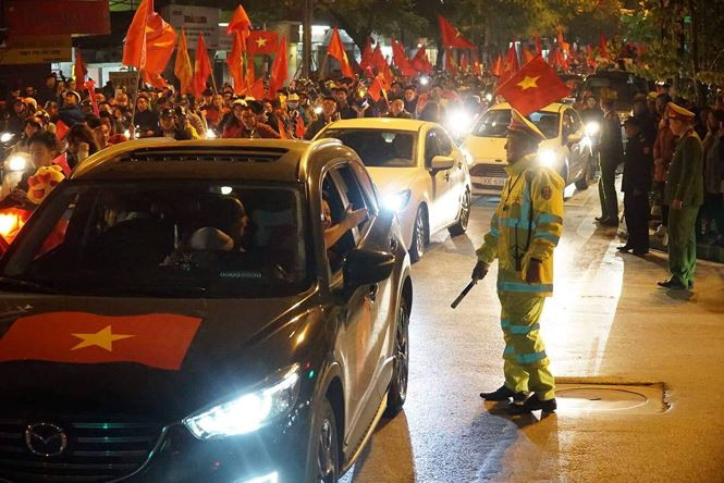 Chiến sĩ CSGT không ngăn được nụ cười chia sẻ niềm vui với người dân cuồng nhiệt khi chứng kiến chiến thắng của đội nhà. Chiến sĩ CSGT không ngăn được nụ cười chia sẻ niềm vui với người dân cuồng nhiệt khi chứng kiến chiến thắng của đội nhà.