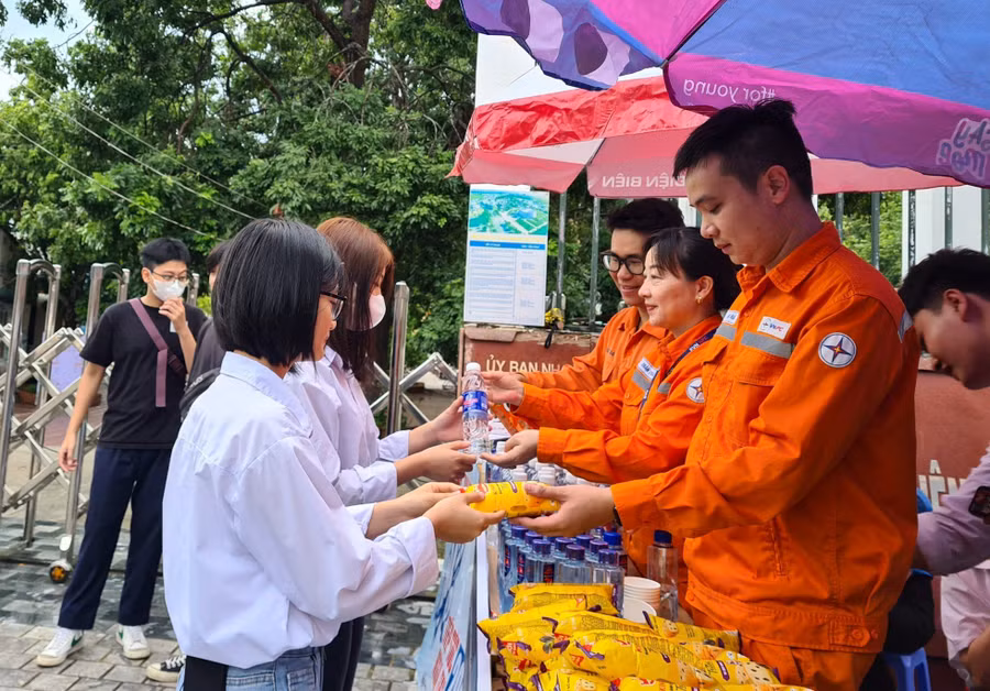 Tình nguyện viên Công ty Điện lực Điện Biên tặng nước uống miễn phí cho thí sinh dự thi tại điểm thi Trường THPT TP. Điện Biên Phủ.