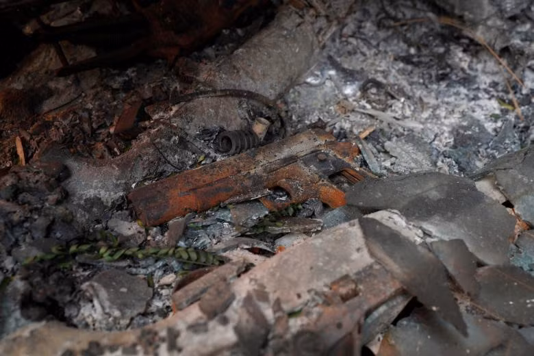 Trong đống đổ nát, người ta tìm thấy những thứ như khẩu súng (trong ảnh). Nó được đánh dấu để di dời sau. New York Times nhận định những hình ảnh của vụ cháy ở bang California không khác gì ảnh chụp tại vùng chiến sự. Ảnh: Reuters.