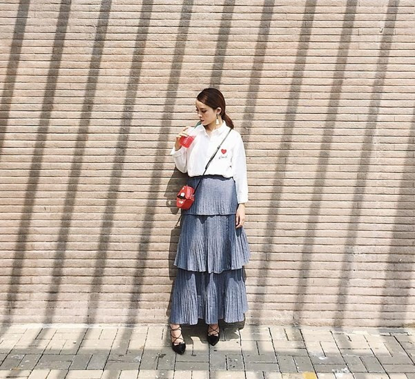 Yến Trang duyên dáng trong thiết kế váy xếp tầng phiên bản maxi. Cách mix cùng áo sơ-mi trắng và giày đan dây giúp giọng ca 32 tuổi cải thiện chiều cao khiêm tốn. Ảnh: FBNV