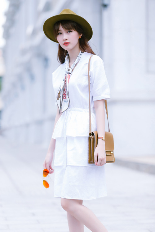 Xu hướng váy xếp tầng được sao Việt và cộng đồng giới trẻ yêu thích trong thời gian qua. Dẫn đầu trào lưu, hoa hậu Đặng Thu Thảo từng diện thiết kế trắng tinh khôi dạo phố vào giữa năm 2015. Bộ váy đơn giản trở nên sống động nhờ phụ kiện trẻ trung, hiện đại. Ảnh: Chanh
