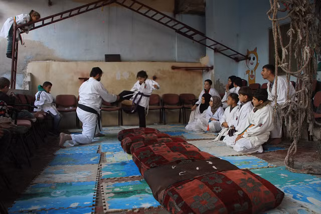 Các lớp học trước đây đã bị tạm dừng sau khi chính phủ Syria liên tiếp tấn công phiến quân ở khu vực xung quanh. Sau một thập kỷ chiến tranh, các lực lượng trung thành với Tổng thống Syria Bashar al-Assad đã chiếm lại một số thành trì trước đây của phiến quân nhưng phe đối lập vẫn tiếp tục nắm giữ lãnh thổ ở phía bắc đất nước, xung quanh thành phố Idlib và ở phía nam giáp Jordan.