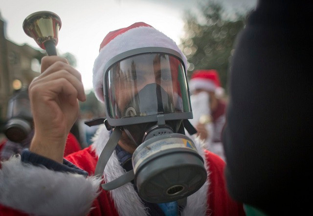 Một người biểu tình Palestine mặc trang phục ông già Noel và đeo mặt nạ chống hơi cay trong cuộc biểu tình phía trước điểm kiểm soát của Israel, Bờ Tây của Bethlehem.