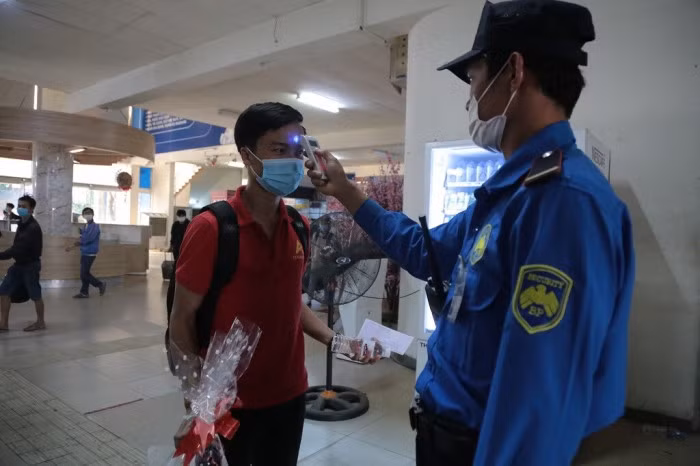 Để phòng chống dịch bệnh Covid-19, hành khách về quê sẽ được lực lượng an ninh kiểm tra thân nhiệt.