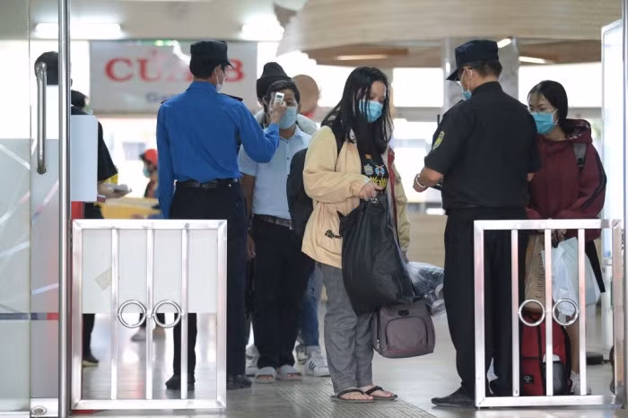 Tại các cổng ra từ nhà chờ ra bãi xe khách luôn có sinh viên xếp hàng dài để chờ đo thân nhiệt trước khi lên xe. Trong khi đó, tại bãi xe nhân viên nhà xe cũng hối hả chất hành lý.