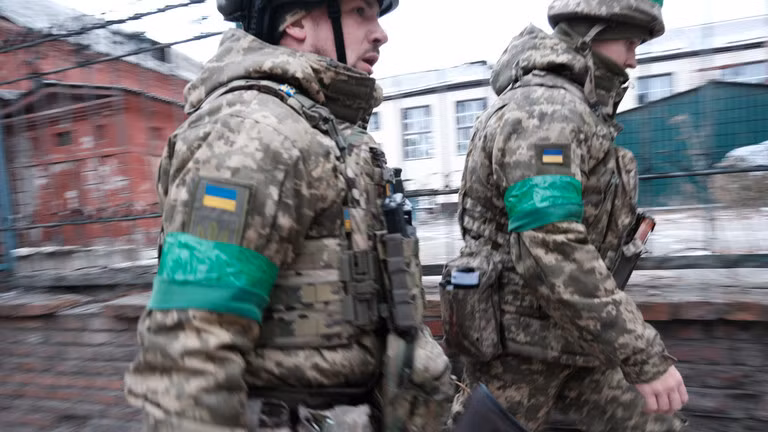 Binh sĩ Ukraine đi bộ qua thành phố Artyomovsk (Bakhmut). (Ảnh: Spencer Platt / Getty Images).