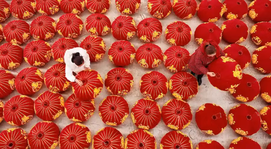 Trung Quốc: Tuy phải vật lộn với đại dịch Covid-19, người dân ở đây vẫn tiếp tục các hoạt động đón mừng năm mới. Người phụ nữ trong ảnh là công nhân sản xuất đèn lồng đỏ trước thềm năm mới ở Đan Trại, Quý Châu (tỉnh Tây Nam Trung Quốc). (Ảnh: AFP).