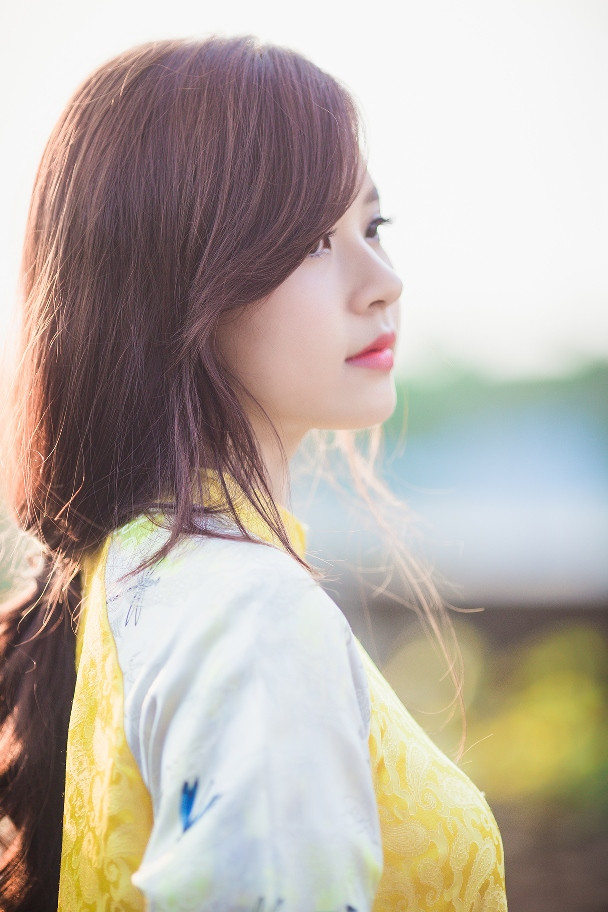 Trong khi đó, bộ áo dài màu vàng kết hợp sắc trắng và hoa văn đơn giản giúp người đẹp toát lên sự sang trọng, rạng ngời.