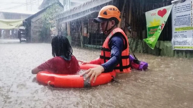 Nhân viên cứu hộ đưa người đi sơ tán.