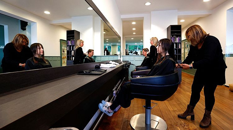 Isabelle Voulkidis, quản lý tiệm tóc Helyode, cắt tóc cho một khách hàng, số tóc này sẽ được tổ chức Dung Dũng thu thập. (Ảnh: REUTERS/Yves Herman)